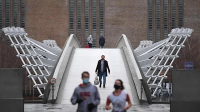 People walk across Millennium bridge in central London. AFP