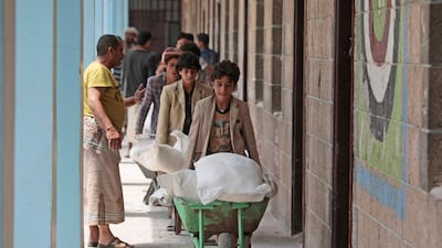 Displaced Yemenis receive food supplies provided by the World Food Programme, at a school in Sanaa. AP