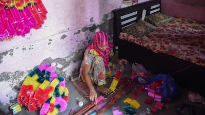 A worker makes garlands from coloured polyster/silk yarn ahead of the Hindu festival of Diwali in Ahmedabad on October 17, 2019. Colourful garlands are in demand during the Hindu festival of Diwali, or Festival of Lights, which falls on October 27 this year. AFP