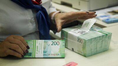 A cashier holds new 200 rouble banknotes in a bank in Moscow. Photo: Reuters