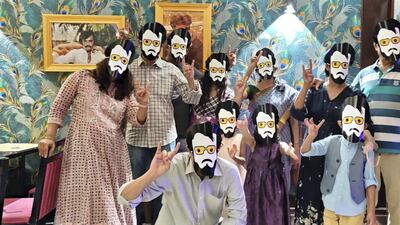 Guests at the new restaurant pose with Rajinikanth masks during the celebrations