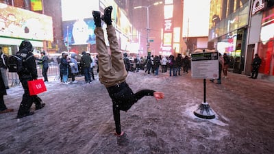 A man performs a one-arm handstand in Times Square. AFP