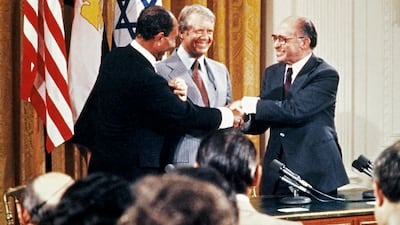 Egyptian President Anwar Sadat, left, Israeli Prime Minister Menachem Begin, right, and US President Jimmy Carter shake hands at the White House on September 17, 1978. AFP