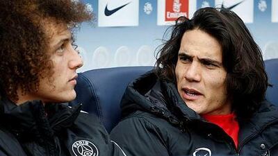 Paris Saint-Germain's David Luiz, left, speaks with teammate Edinson Cavani during the French Ligue 1 match against Caen at the Parc des Princes stadium in Paris on February 14, 2015. The match ended in a 2-2 draw. AFP PHOTO / KENZO TRIBOUILLARD
