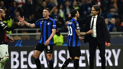 Inter Milan's manager Simone Inzaghi, right, congratulates his Turkish midfielder Hakan Calhanoglu at the end of the Champions League semi-final second-leg against AC Milan. AFP