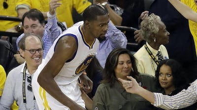 Singer Rihanna, right, watches as Golden State Warriors' Kevin Durant, left, runs past during the second half in Game 1 of basketball's NBA Finals against the Cleveland Cavaliers Thursday, June 1, 2017, in Oakland, Calif. Marcio Jose Sanchez / AP Photo