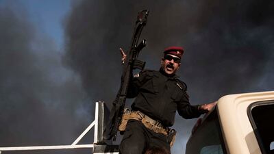An Iraqi army soldier gestures above an accused ISIS member who tried to flee Mosul on October 31, 2016. Photo: Alessio Romenzi
