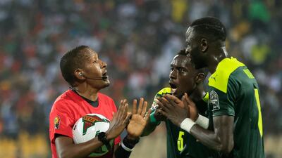 Senegal's Idrissa Gana Gueye argue with referee Bamlak Tessema Weyesa. Reuters