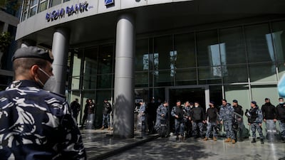 Riot police stand guard in front of a Lebanese bank after depositors tried to storm a lender in Beirut. A dizzying currency collapse has left many people watching on helplessly as their savings evaporate. AP