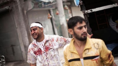 Two Syrians cry for help outside Dar Al Shifa hospital for a Syrian child who lies wounded in a lorry after being shot by the Syrian Army.