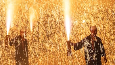 Traditional arm-held firework performers, hold a tezutsu hanabi, hand-crafted bamboo tube packed with gunpowder that erupts in a towering column of sparks and flame, during a festival in Tatebayashi, Japan. AFP