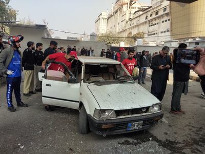 Rescue officials inspect a car used in the attack. EPA