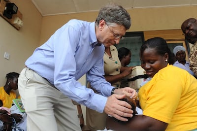 Bill Gates gives a child a rotavirus vaccine dose in Awutu Senya, Ghana. AFP