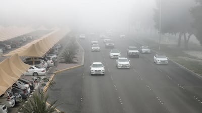 Cars emerge from early morning fog on Muroor Road in Abu Dhabi. Victor Besa / The National