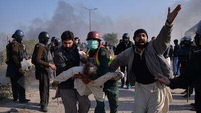 An injured activist from a religious group is carried away from clashes with police in Islamabad. AFP/Aamir Qureshi