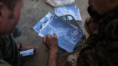 A 40 and a 21 year old from the UK nick-named by Kurdish fighters as Hewal Cudi, left, and Hewal Sores check maps in the outskirts of the north-western Syrian town of Tal Tamr, north of Hasakeh, near the border with Turkey, as they fight alongside People Protection Unit (YPG) fighters under the commanders, Sider and Gerzan.