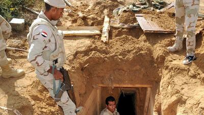 Egyptian soldiers inspect a smuggling tunnel in the divided border town of Rafah, along the border with the Hamas-run Gaza Strip, on November 4, 2014. Egypt is demolishing more than 800 homes in a bid to create a buffer zone aimed at combating militants they say are infiltrating from across the border. Mohamed El Sherbeny/AFP Photo