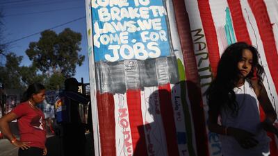 A banner painted by migrants in the colours of the US flag is displayed outside a temporary shelter set up for members of the 'migrant caravan' at a football complex in Tijuana, Mexico. Getty