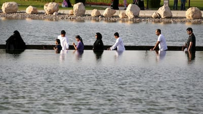 Visitors are seen crossing the lake at Dubai's Quranic Park. Reuters