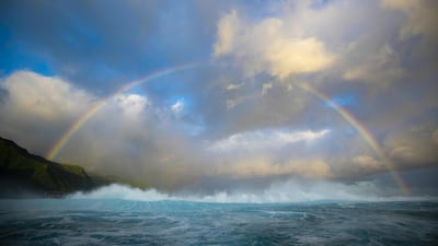 A rainbow pierces through the clouds behind the famous break of Teahupoo in Tahiti, French Polynesia. AFP