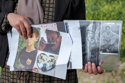 Bahar Elias, 40, a displaced Yazidi, holds pictures of her family members kidnapped by ISIS. AFP