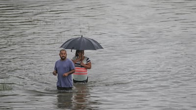 People walk the flooded waters after heavy rain and flooding from the remnants of Tropical Depression Imelda dumped more than two feet of water across some areas. Getty