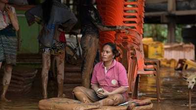 Residents return to their homes damaged by flood waters in a village in Sanamxai, Attapeu province. AFP