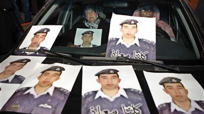 Safi Al Kaseasbeh and his wife sit in a car with pictures of their son, Jordanian pilot Lieutenant Maaz Al Kaseasbeh, who is being held by ISIL. Raad Adayleh/AP Photo
