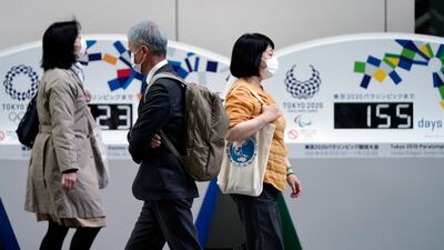 Pedestrians walk past a Tokyo Olympics countdown clock in Tokyo. EPA