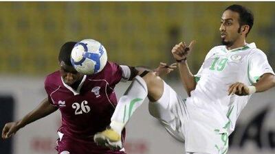 Qatar’s Bilal Rajab, left, fights for the ball with Saudi Arabia’s Ahmad Abbass in their Group A Gulf Cup match in Aden last night. Saudi Arabia equalised in last minute to deny their opponents a semi-final spot.