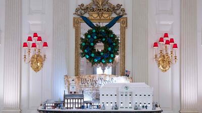 A gingerbread White House in the State Dining room is displayed in front of a copy of the preamble of the US Constitution. AFP