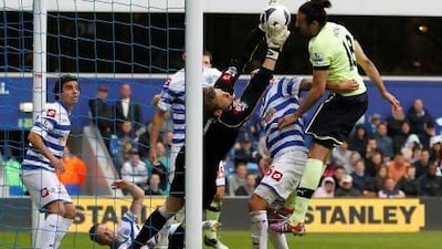 Robert Green, left, the QPR goalkeeper catches the ball under a challenge from Jonas Gutierrez. Ian Kington / AFP