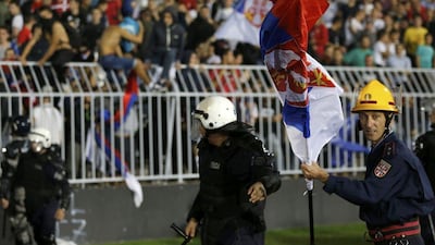 A firefighter and riot police scramble as fans begin to invade the pitch at Partizan Stadium on Tuesday during the Euro 2016 qualifier between Serbia and Albania. Marko Djurica / Reuters