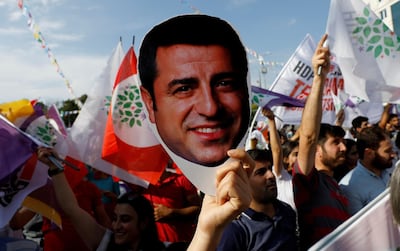 A supporter of the pro-Kurdish Peoples' Democratic Party holds a mask of their jailed former leader Selahattin Demirtas during a rally in Ankara last month. Reuters