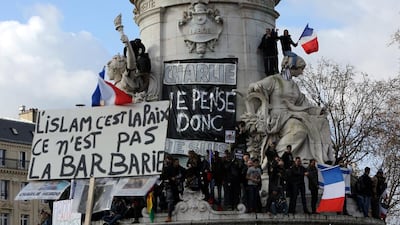 A placard reading ‘Islam is peace, not barbarism’ is held up against another that says ‘Charlie, I think therefore I am’ during a peace rally in Paris following the killings at Charlie Hebo magazine in January 2015. AFP Photo