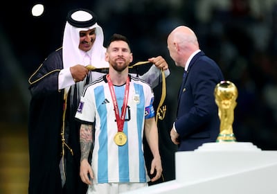 Sheikh Tamim bin Hamad Al Thani, Emir of Qatar, drapes the bisht over Lionel Messi's shoulders as Fifa president Gianni Infantino looks on. Reuters