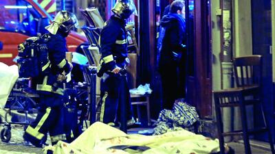 Rescue workers walk past victims in the 10th district of Paris. At least 35 people were killed November 13, 2015, in shootings and explosions around Paris, many of them in a popular concert hall where patrons were taken hostage, police and medical officials said. Jacques Brinon / Associated Press