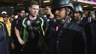 James Faulkner of Australia looks on armed guards walk past during the ICC World Twenty20 match between Australia and Bangladesh at M. Chinnaswamy Stadium on March 21, 2016 in Bangalore. Ryan Pierse / Getty Images