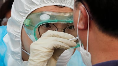 A medical staff wearing protective suits takes samples from a man during Covid-19 testing at a hospital in Seoul, South Korea. AP Photo