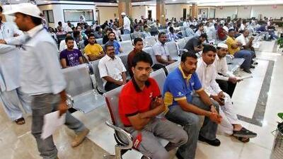 Men wait to be fingerprinted and photographed during the registration process for their Emirates ID cards at the Emirates ID Authority in Al Barsha, Dubai.