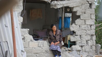 A woman sits in ruins of her house after shelling by Armenian's artillery during fighting over the separatist region of Nagorno-Karabakh, in Terter, Azerbaijan. AP