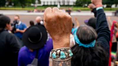 Members of the Carrizo Comecrudo Tribe of Texas hold up their fists as indigenous and environmental activists protest in front of the White House in Washington. AP