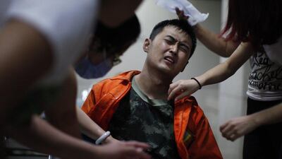 Medical staff treat an injured rescuer in a hospital in Tianjin. AFP Photo