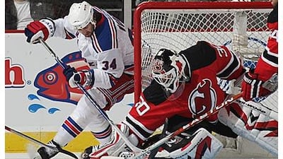 The Devils' Martin Brodeur thwarts a wraparound attempt by the Rangers' Aaron Voros.
