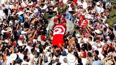 Mourners carry the coffin of the slain opposition leader Mohammed Brahmi at his funeral procession in Tunis on Saturday. Zoubeir Souissi / Reuters