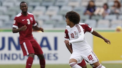 UAE football player Omar Abdulrahman, near, dribbles around Qatar defenders on Sunday in his side's 4-1 Asian Cup victory. Tim Wimborne / Reuters