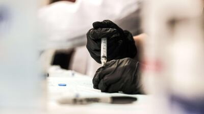 A pharmacy volunteer prepares doses of the Johnson & Johnson vaccine during a pop-up clinic at Western International High School on April 12, 2021 in Detroit, Michigan. Getty Images / AFP
