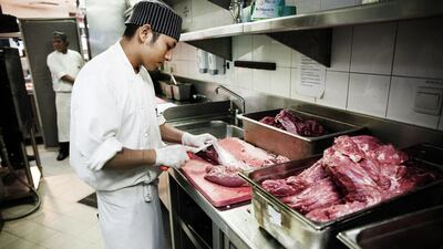 Cooks prepare meat in the kitchen of Ruth's Chris Steak House, Dubai Marina. Anna Nielsen for The National.
