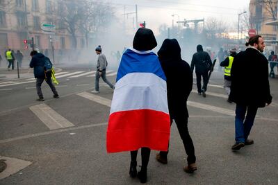 A protestor in a French flag pictured during 'yellow vest' on Saturday in Lyon. AFP