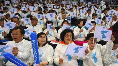 Korean fans waving "unification flags" as they cheer for North Korean players during the IIHF women's world ice hockey championships division II group A competition match between South Korea and North Korea in Gangneung in April 2017. The two Koreas agreed on January 17, 2018 to march together under a single flag at the Winter Olympics opening ceremony and field a united women's ice hockey team for the Games in a further sign of easing tensions on the peninsula. North Korea also said it would send a 550-member delegation to the Winter Olympics and Paralympics in the South, Seoul said, as the two sides met to discuss athlete numbers in the latest in a flurry of cross-border talks. / AFP PHOTO / JUNG Yeon-Je